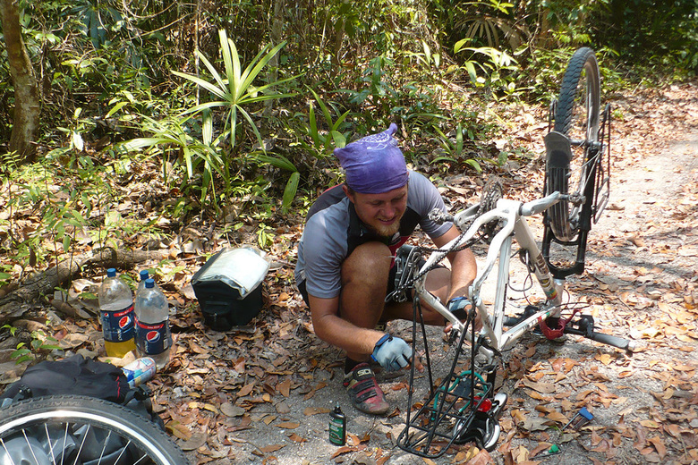Kybi repairing bike in the jungle